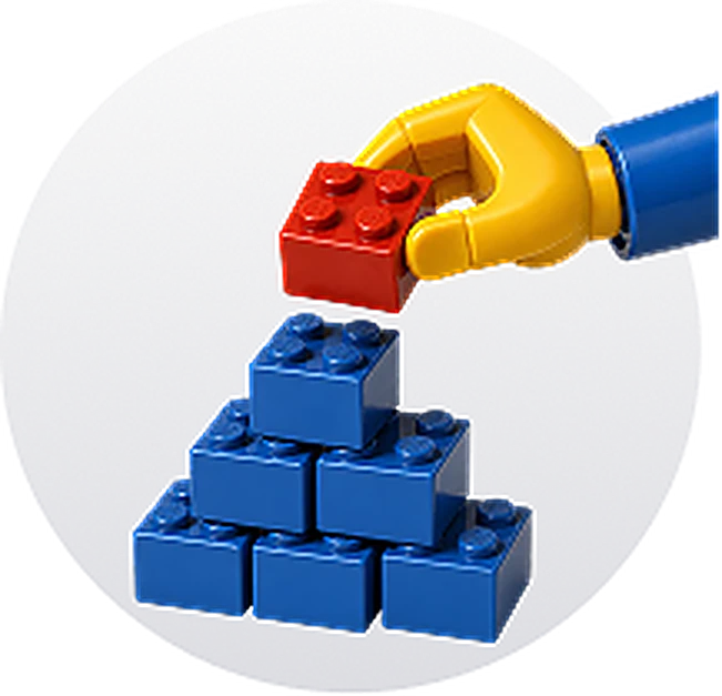 A hand placing the final brick on a stack
